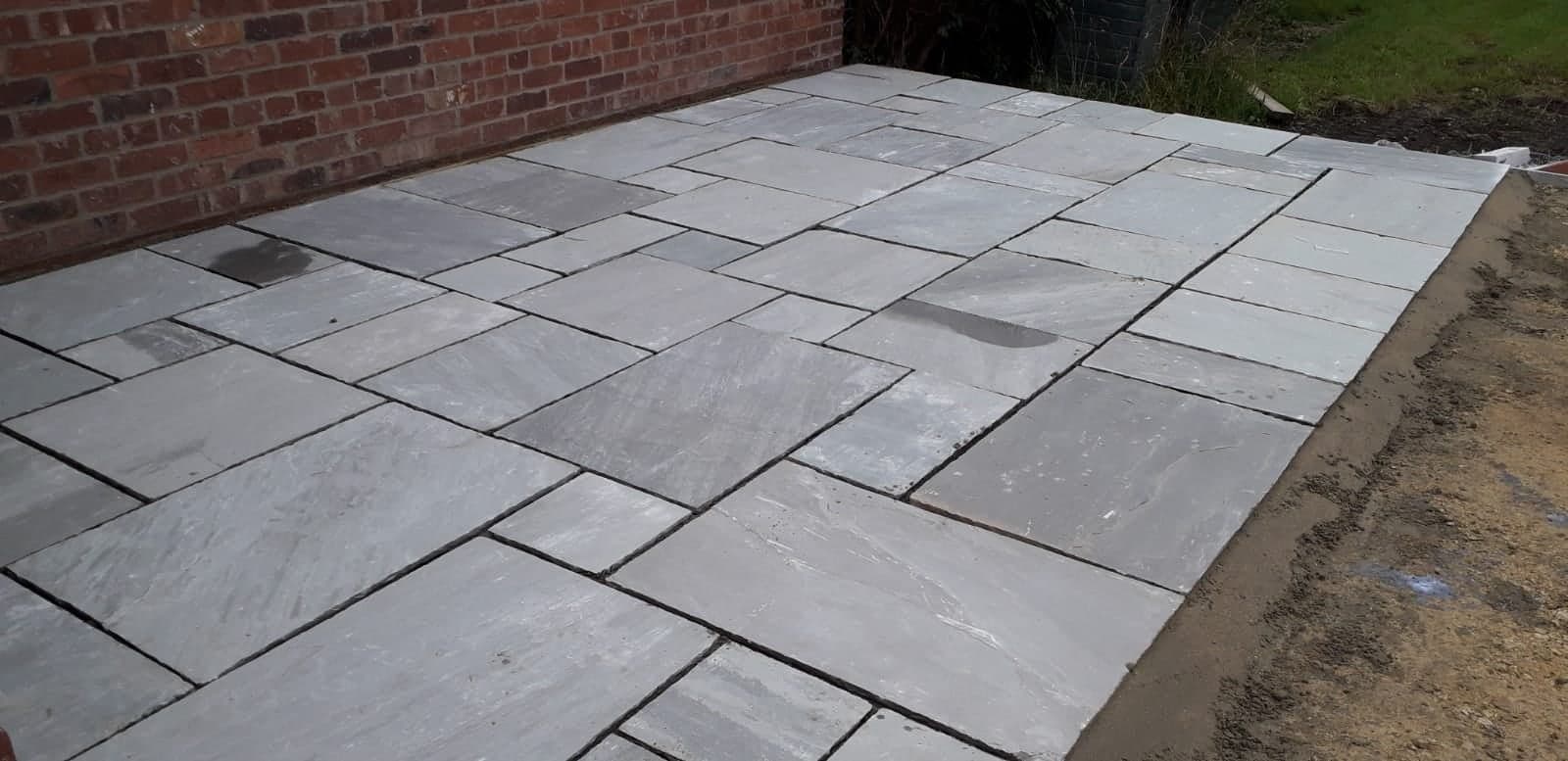 Finished patio paving beside a brick property